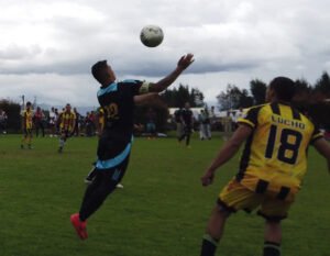 jugador saltando por balon en torneo de fútbol 8