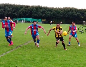 Jugadores corriendo en torneo de futbol 8 en Bogotá