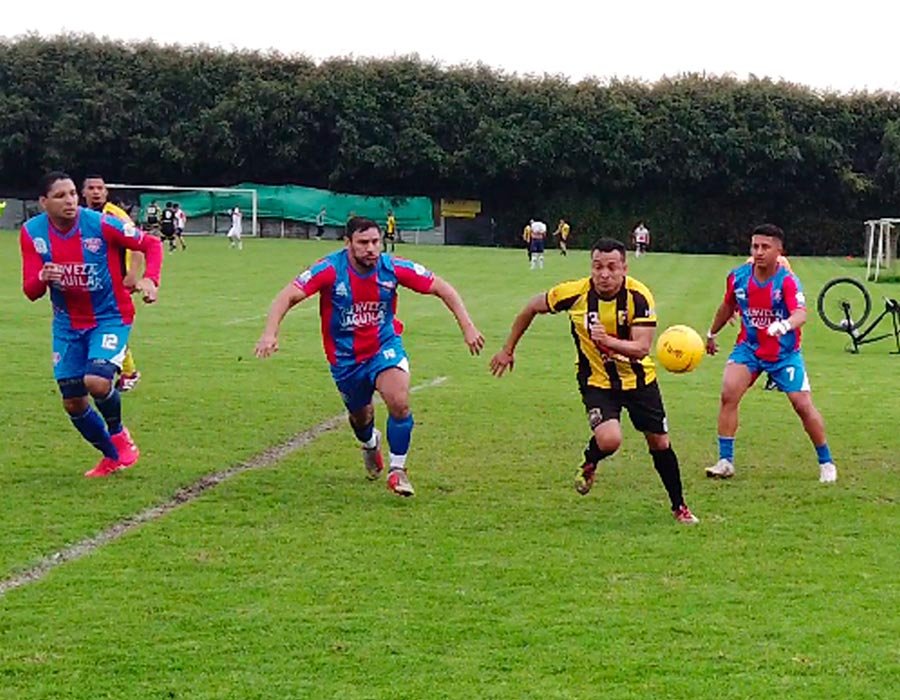 Jugadores corriendo en torneo de futbol 8 en Bogotá